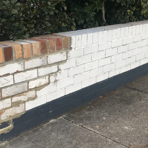 A photograph showing a bulging brick wall in need of repair.